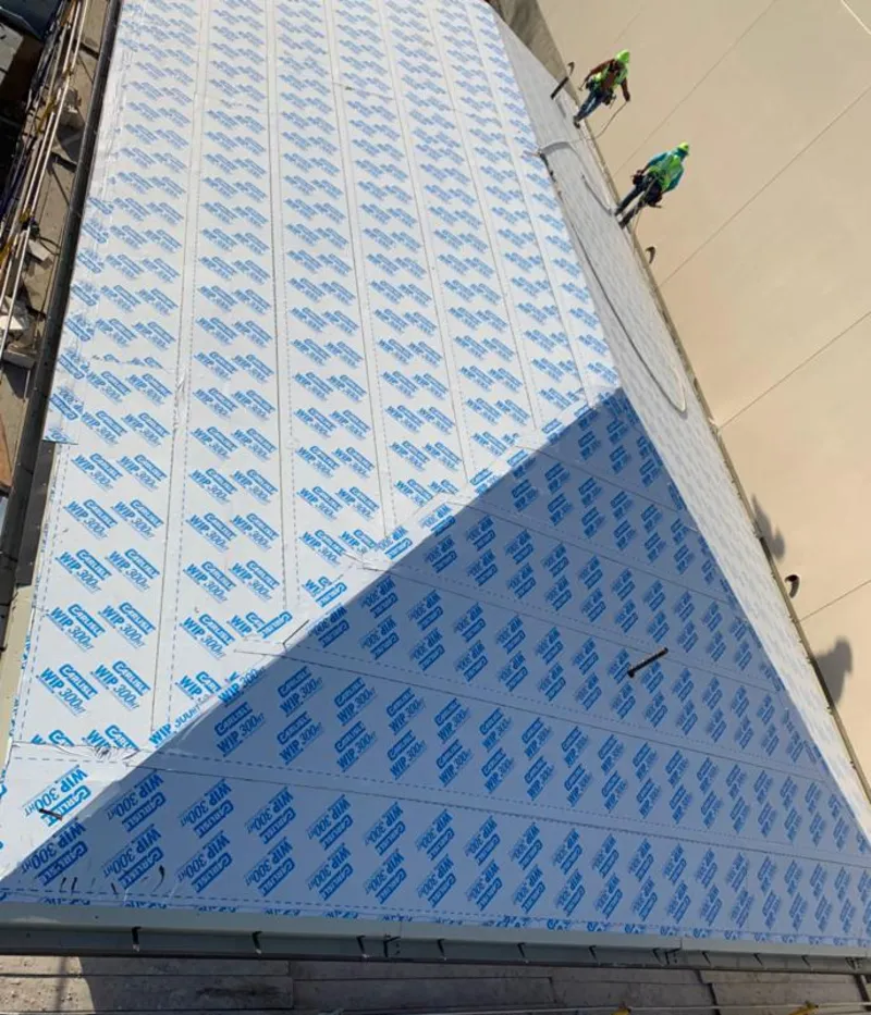 Professional roofers installing underlayment on a metal roof in Lower Merion